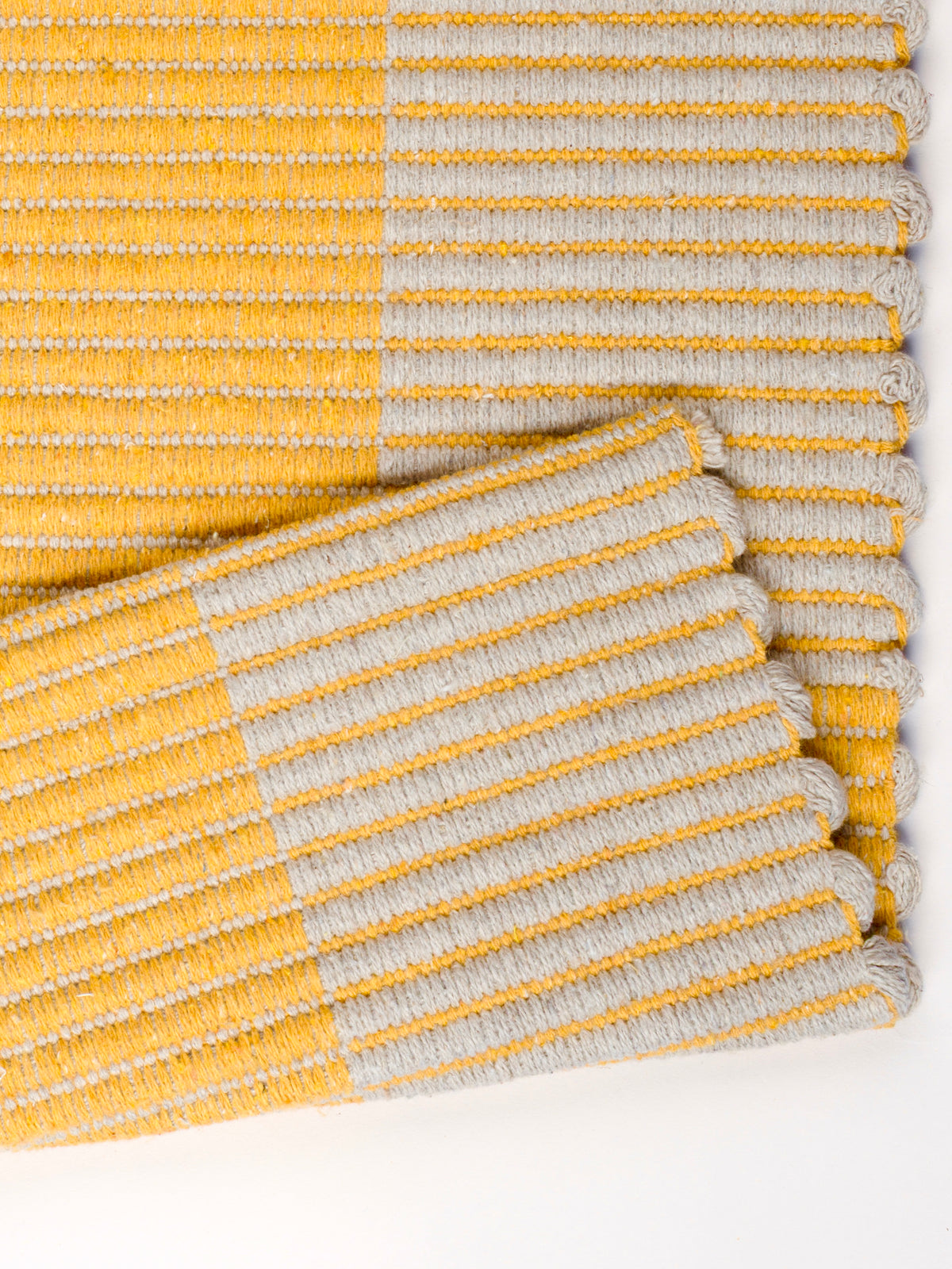 Detalhe do padrão quadriculado amarelo e cinza claro do tapete Chroma