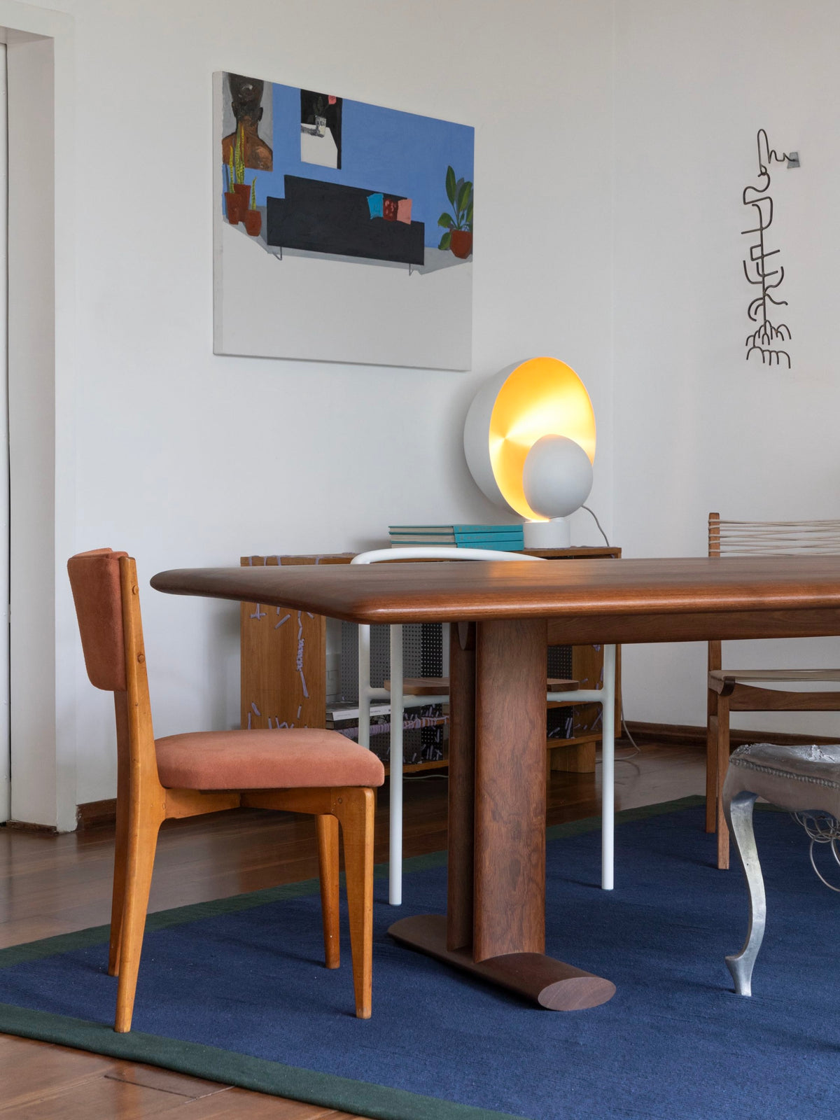 Tapete Duo Borda Azul e Verde com borda da Leva Oficina em sala de jantar contemporânea, com mesa de madeira, cadeiras vintage e decoração autoral.