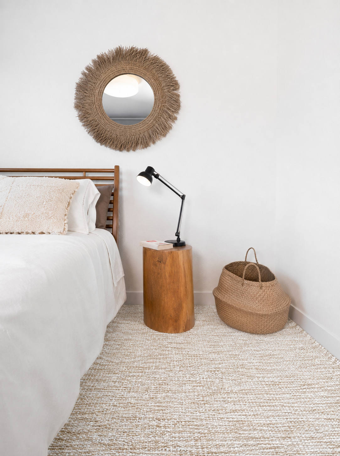 Tapete Pontal Bege ao lado de uma cama com mesa de madeira e cesto de fibras naturais.