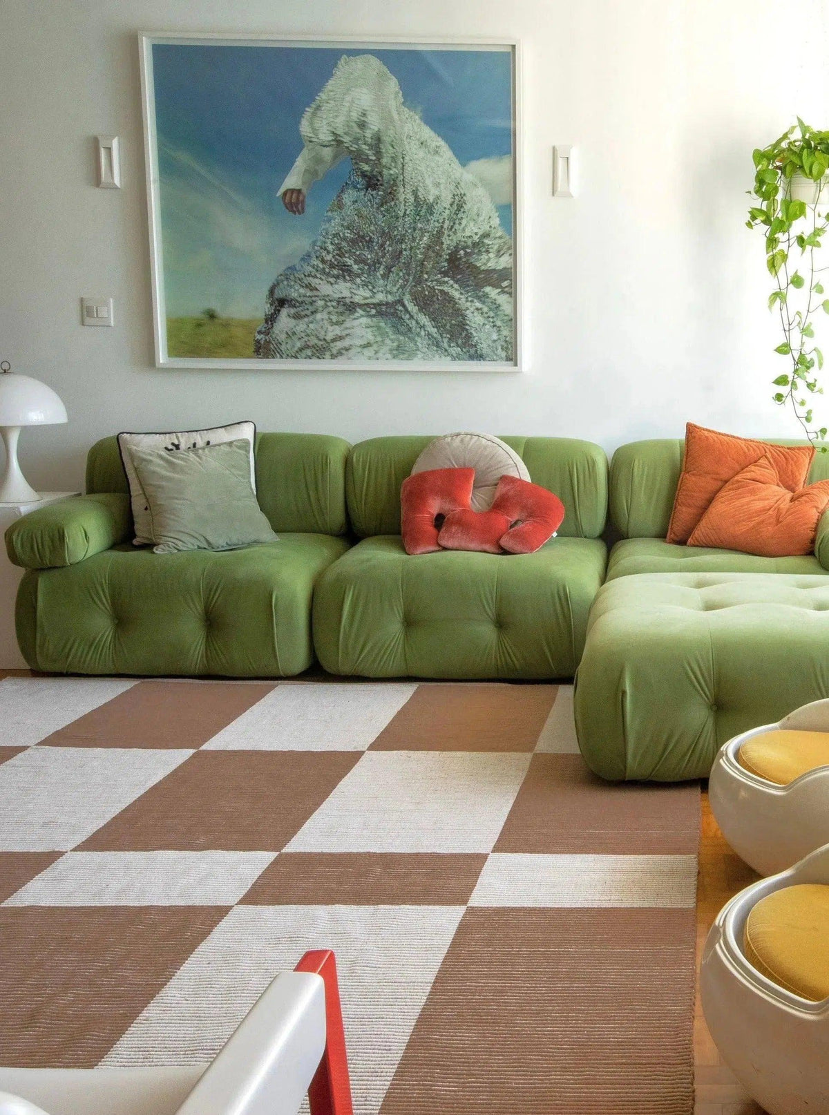 Tapete Chroma quadriculado cru e camelo em sala de estar com sofá verde e almofadas coloridas.